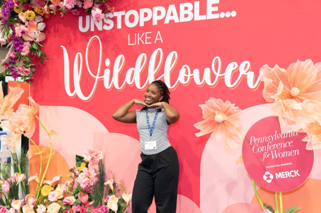 Pennsylvania Conference for Women 2024 attendee in front of flower wall