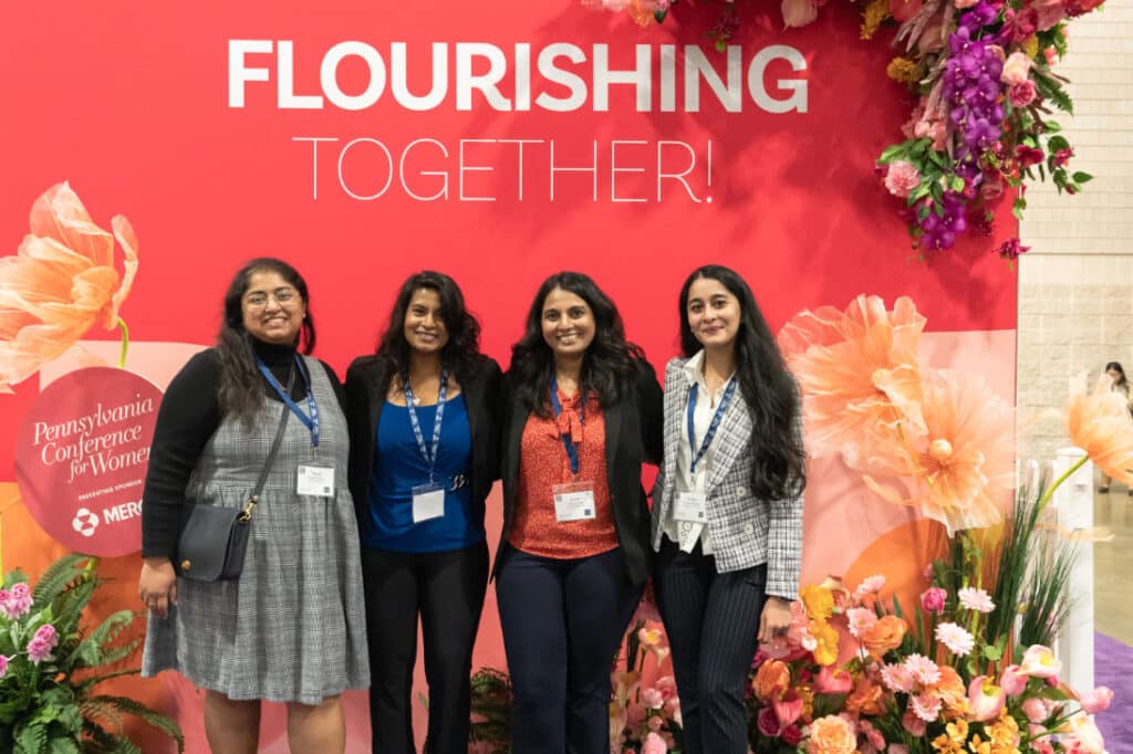 Pennsylvania Conference for Women 2024 attendees in front of flower wall